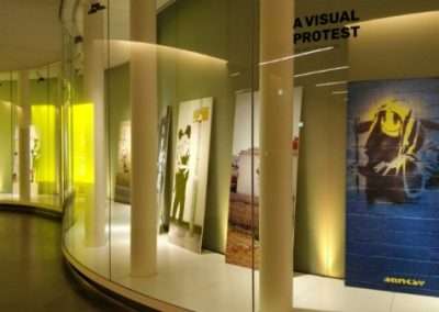 muro della mostra con le opere artistiche allestito ed retro illuminato da Key Comunicazione.