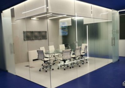 La KEY Comunicazione ha progettato e realizzato il restyling funzionale dell’ingresso della nuova sede della società GoldBet. Nell'immagine l'escena di una sala riunioni moderna con arredamento di design in coore bianco come le pareti interne. Esternamente il colore blu.