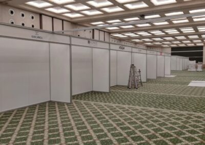 Fase d'allestimeno delllo stand dell. nell'immagine si vede la struttura inportante color legno e separatori che formano le parete divisorie color beige.