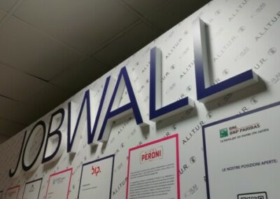 abbiamo realizzato l'allestimento dell'evento CareerDay per Alitur. In questa immagine una visuale ravvicinata della scritta JobWall sulla parete da sfondo biando in cui sono pubblicate diverse opportunità di lavoro per i graduandi.