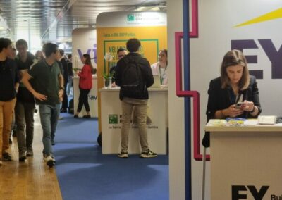 Un corridoio evidenziato da un tappetto di colore blu in cui si posizionano gli stand delle diverse aziende che si sono presentati all'evento CareerDay all'Università Torvergata di Roma per Alitur. Allestimento per Key Comunicazione.