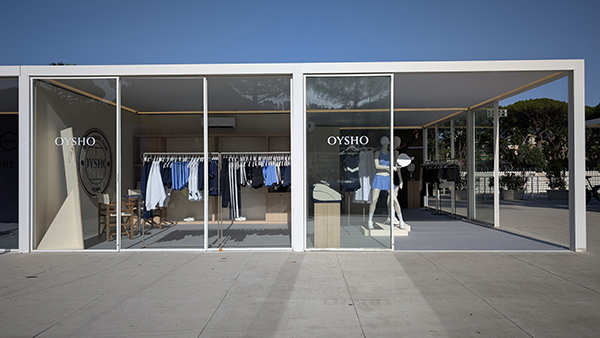 Vista frontale esterna dello stand Oysho by Key Comunicazione. Due moduli espositivi in vetro con struttura modulare e linee essenziali. Manichini visibili dall’esterno, espositori ordinati e logo Oysho in vetrofania. Integrazione perfetta con l’ambiente outdoor.