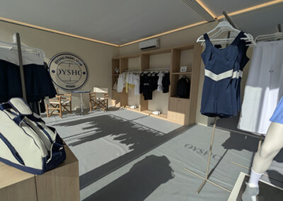Vista d’insieme dello stand Oysho: allestimento fieristico con manichini, borsa sportiva e pannelli in vetro.