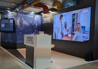 Schermo LED con scena clinica nello stand Storz all’AIIC di Napoli 2025 progettato da Key Comunicazione, con banco informativo e grafiche immersive.