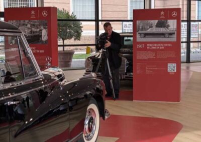 Un fotografo immortala una delle 8 Mercedes-Benz utlizzata come Papamobile accanto alle infografie